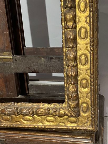 null A carved and gilded wood frame with an upside-down profile, decorated with a...