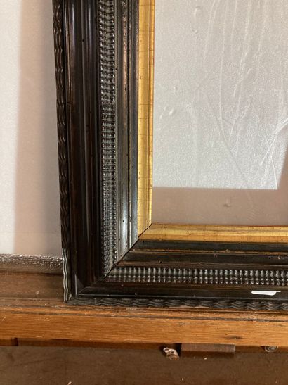 null A blackened molded wood frame with inverted profile and guilloché decoration,...