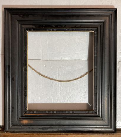 null A frame in blackened molded wood, gilded rebate and guilloche baguettes in the...