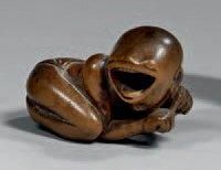 JAPON - XIXème siècle Netsuke en bois, personnage allongé sur le ventre, la tête...