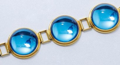 LALIQUE Bracelet en métal doré orné d'une suite de pierres bleues en cabochon. Signé....