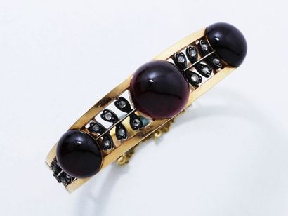 null Bracelet jonc ouvrant en or 18 K ajouré, rehaussé de 3 beaux cabochons de grenat...