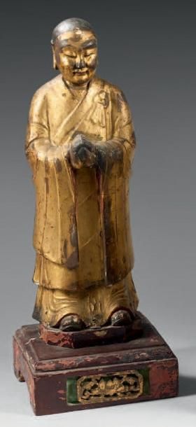 CHINE Statuette de moine en bois laqué or, debout, les mains cachées dans les manches...