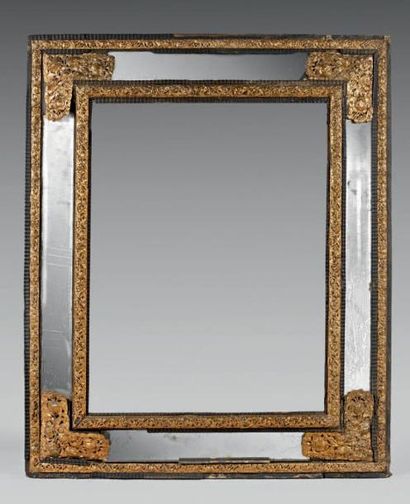  Glace à profil inversé dans un cadre partiellement foncé de miroir, à décor de cuivre...