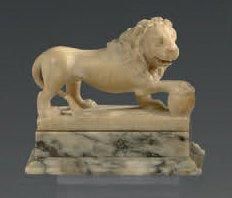 null Lion en albâtre représenté debout tenant une sphère sous sa patte droite; socle...