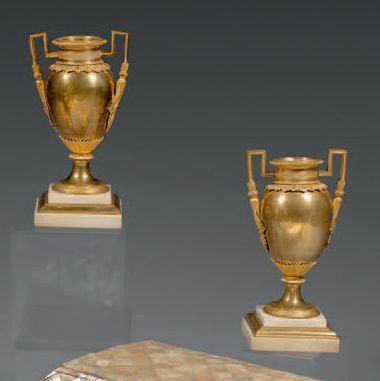 null Paire de vases en bronze ciselé et doré et marbre blanc. Les cols à rang de...