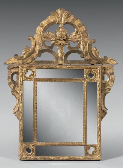 null Petit miroir dans un cadre à parcloses en bois sculpté et doré; le fronton orné...
