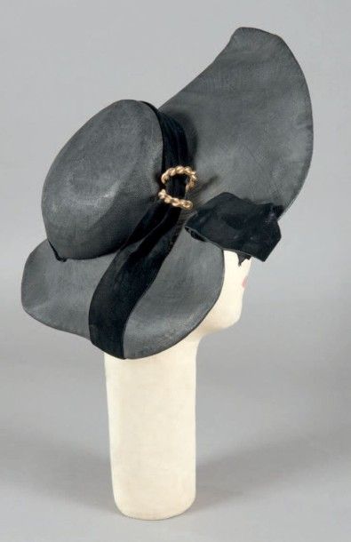 ROSE VALOIS, vers 1950 Capeline «New look» en paille fine vernis noire asymétrique...