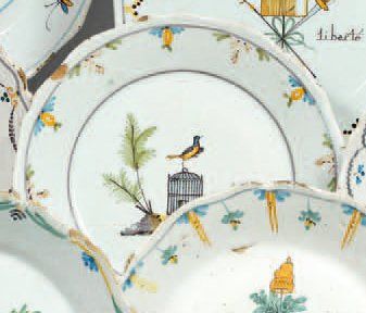 NEVERS Assiette à bordure contournée, décor polychrome d'un oiseau perché sur une...