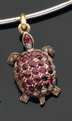 null "Charm's" en or ciselé stylisant une tortue, la carapace pavée de rubis ronds...
