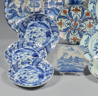 DELFT Cinq assiettes circulaires dont quatre décorées en camaïeu bleu de paysages...