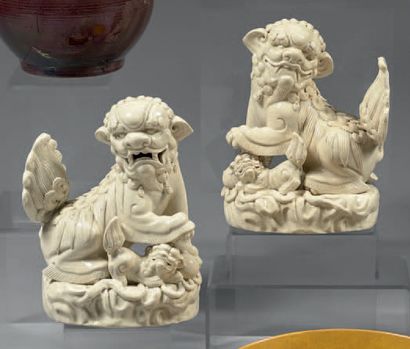 CHINE Paire de figurines à couverte monochrome blanche représentant deux chiens de...