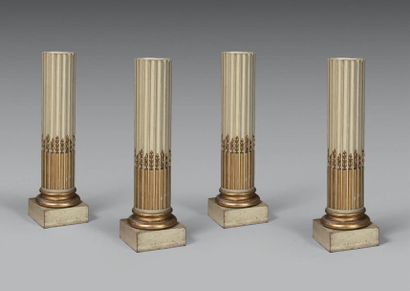 null Suite de quatre colonnes tronquées en stuc doré rechampi gris, les futs cannelés...