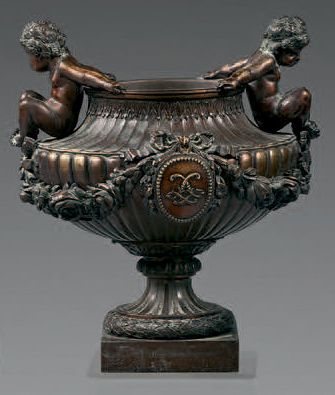 null Vase en bronze ciselé à patine médaille; la panse à godrons centrée d'un médaillon...