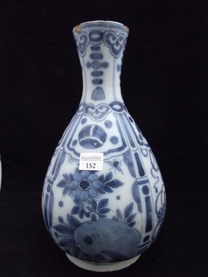 DELFT. Vase bouteille, décor en camaïeu bleu de motifs fleuris et de symboles taoïstes...