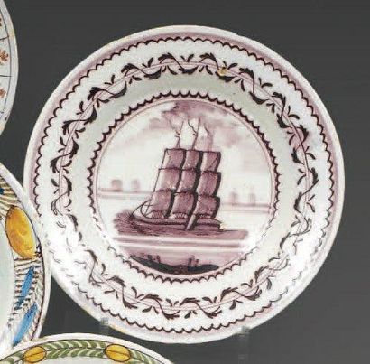 DELFT. Assiette ronde, décor en manganèse d'un navire trois mats, encadré d'une guirlande...