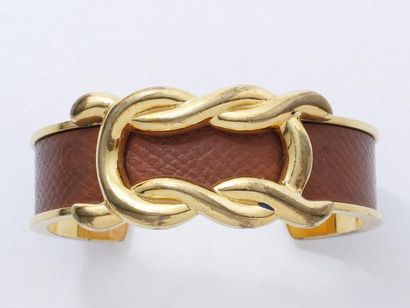 null HERMES
Bracelet jonc ouvert en métal doré et cuir marron, à décor de noeud plat....
