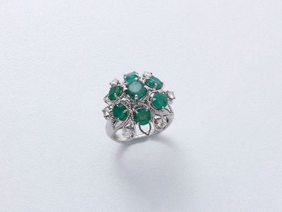 null Bague en or gris 750 millièmes stylisant une fleur habillée d'émeraudes facettées...