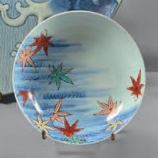 JAPON, NABESHIMA Coupe circulaire sur talon en porcelaine, décorée de feuilles traitées...