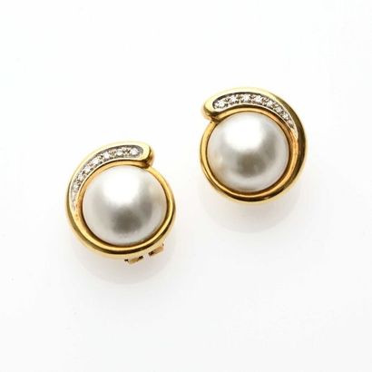null Pair of 18K (750° thousandths) yellow gold earrings centered with a half pearl...