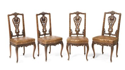 null Quatre chaises à dossier ajouré en bois sculpté de coquilles. Garniture de cuir...