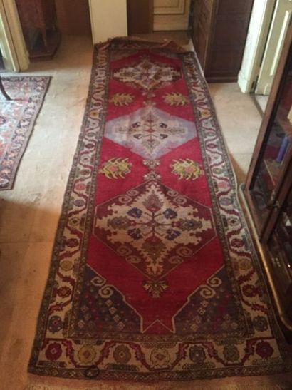 null Small rectangular woollen rug with a floral pattern on a red and beige background....