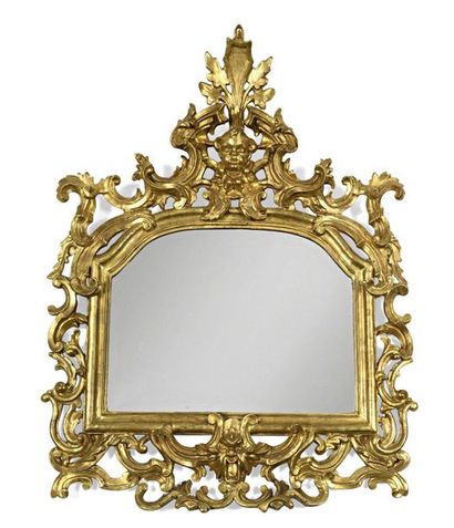 null A gilded wooden mirror in the form of a hat carved with interlacing rocailles,...