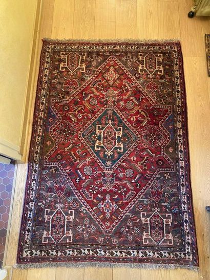 null Wool oriental rug decorated with a green central medallion on a red background....