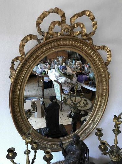 null Miroir ovale en bois et stuc doré à décor de godrons et rubans Hauteur : 104...