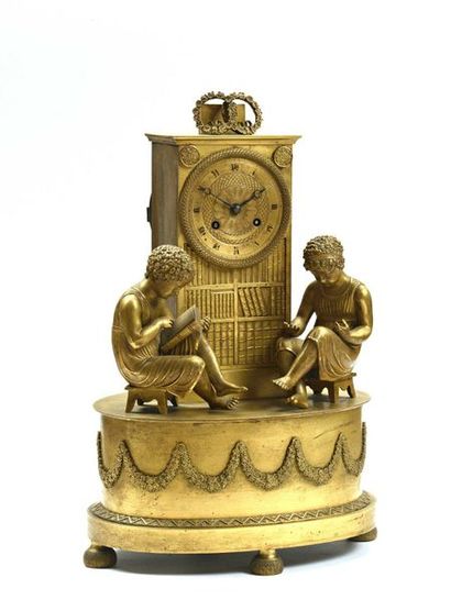null 377 Pendule en bronze doré représentant deux enfants lisant devant une bibliothèque....