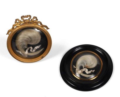 null 48 Two medallions of hair curls, one in a gilt bronze frame decorated with ribbon...