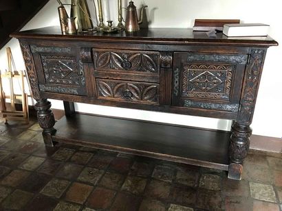 null Sideboard in natural wood molded and carved with stylized motifs and foliage...