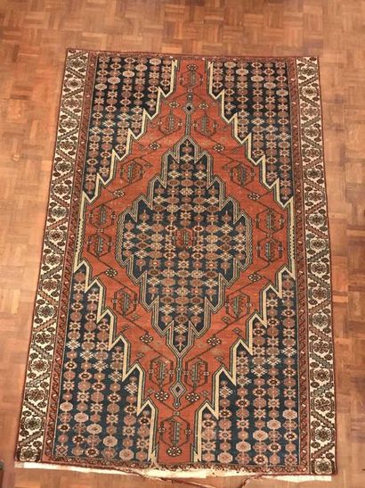 null Wool carpet decorated with a red medallion on a blue background Wear 146x103cm...