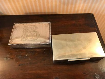 null Two cigarette boxes in silver metal, one with a single flat decoration, the...