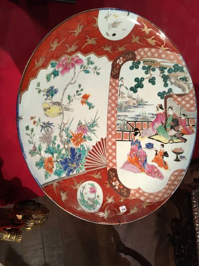 null 196 Japon Grand plat rond en porcelaine à décor polychrome de scènes de palais...