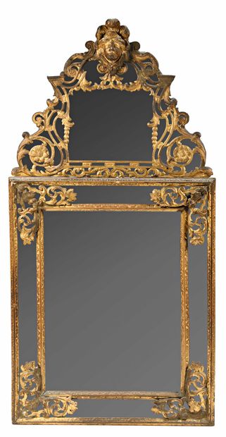 null 227 Important miroir à parecloses en bois doré à décor de feuillage et mascaron....