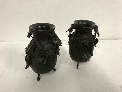 null A pair of bronze tripod vases with a brown patina, carved with flowers, insects...