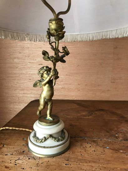 null Petite lampe en bronze doré à décor d’un angelot tenant un bouquet de lumière,...