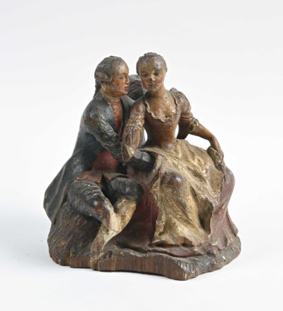 null Carved and polychrome wood group representing a seated couple indulging in gallant...