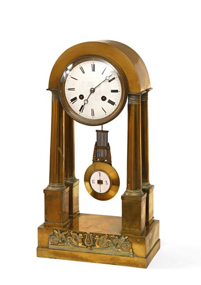 null Portico clock in gilded bronze with curved pediment enclosing the white enamelled...