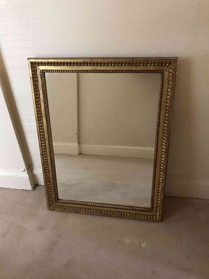 null Miroir en bois doré à décor de frise de perles et de feuilles d eau. XIXème...