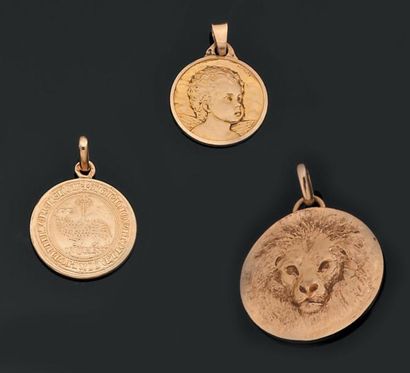 null Lot en or jaune composé de trois médailles pendentif à décor estampé et d'un...