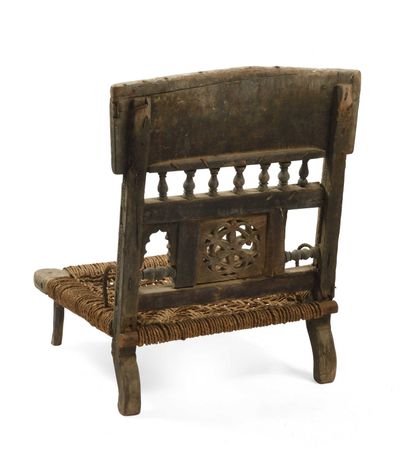 null India. Low chair in wood, carved decorations, balusters and openwork rose. 55...