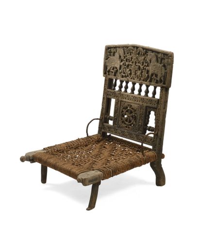 null India. Low chair in wood, carved decorations, balusters and openwork rose. 55...