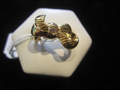DIOR Bague en or jaune (750) à motif d'un ruban noué sertie au centre d'un diamant...