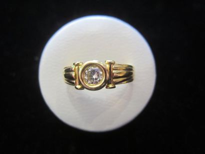 null Bague en or jaune (750) sertie clos au centre d'un diamant (0,20 ct environ)...