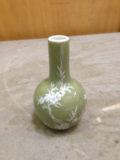 null Petit vase à long col en porcelaine émaillée verte, décor de fleurs blanches....