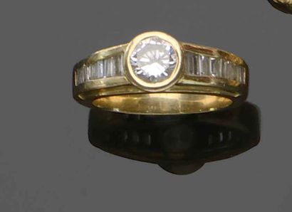 null Bague en or jaune 18K (750) sertie d’un diamant taillé en brillant épaulé d’une...