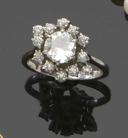 null Bague en or gris 18K (750) sertie d’un diamant ½ taille entourée de diamants...