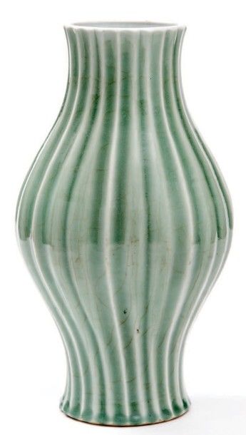 CHINE - XVIIIe siècle 
Vase de forme balustre à col rétréci et côtelé en porcelaine...